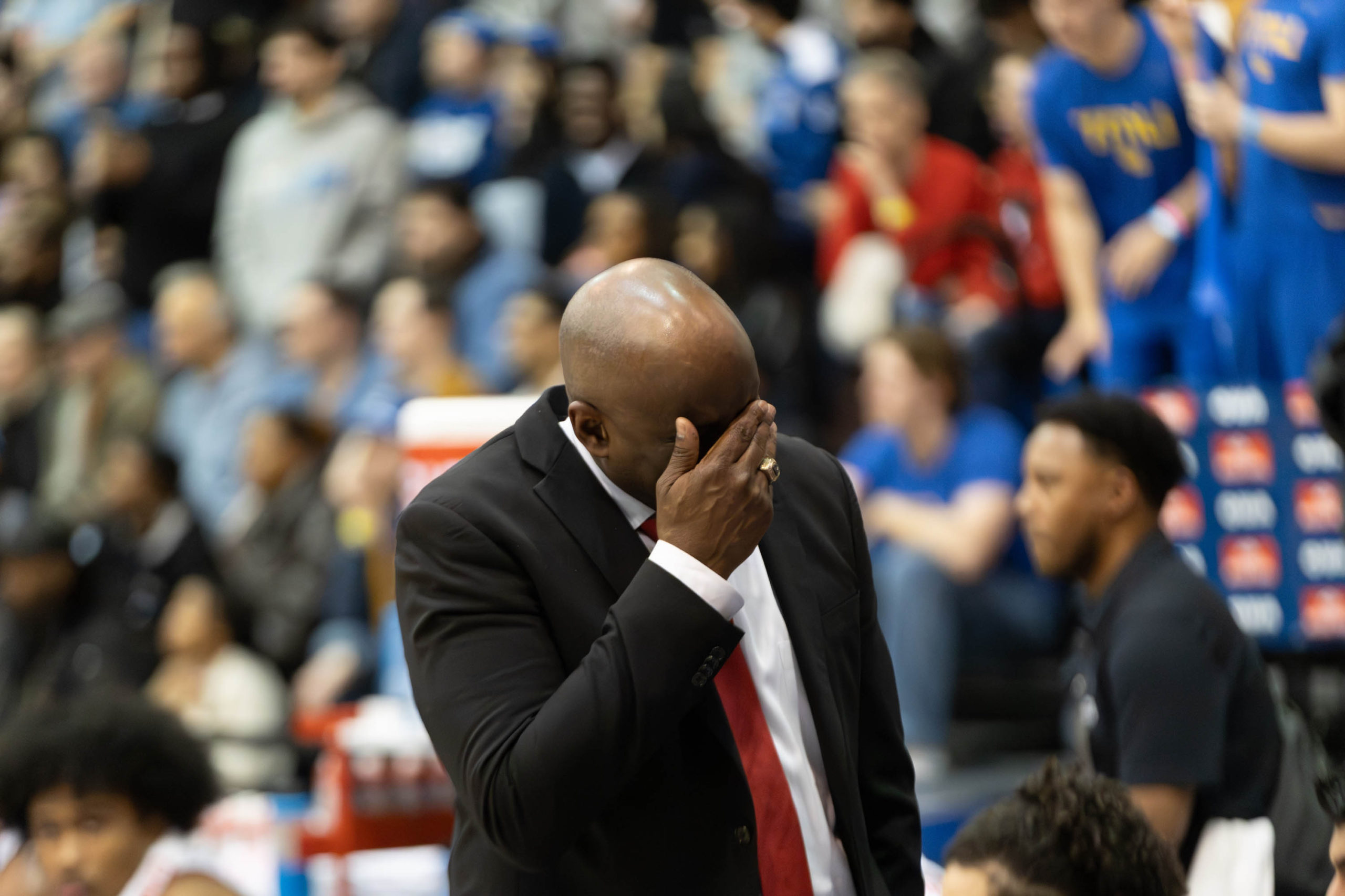 Carleton Ravens head coach with his hand covering his face in frustration at the Mattamy Athletic Centre