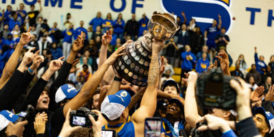 TMU men's basketball team hoisting up the Wilson Cup