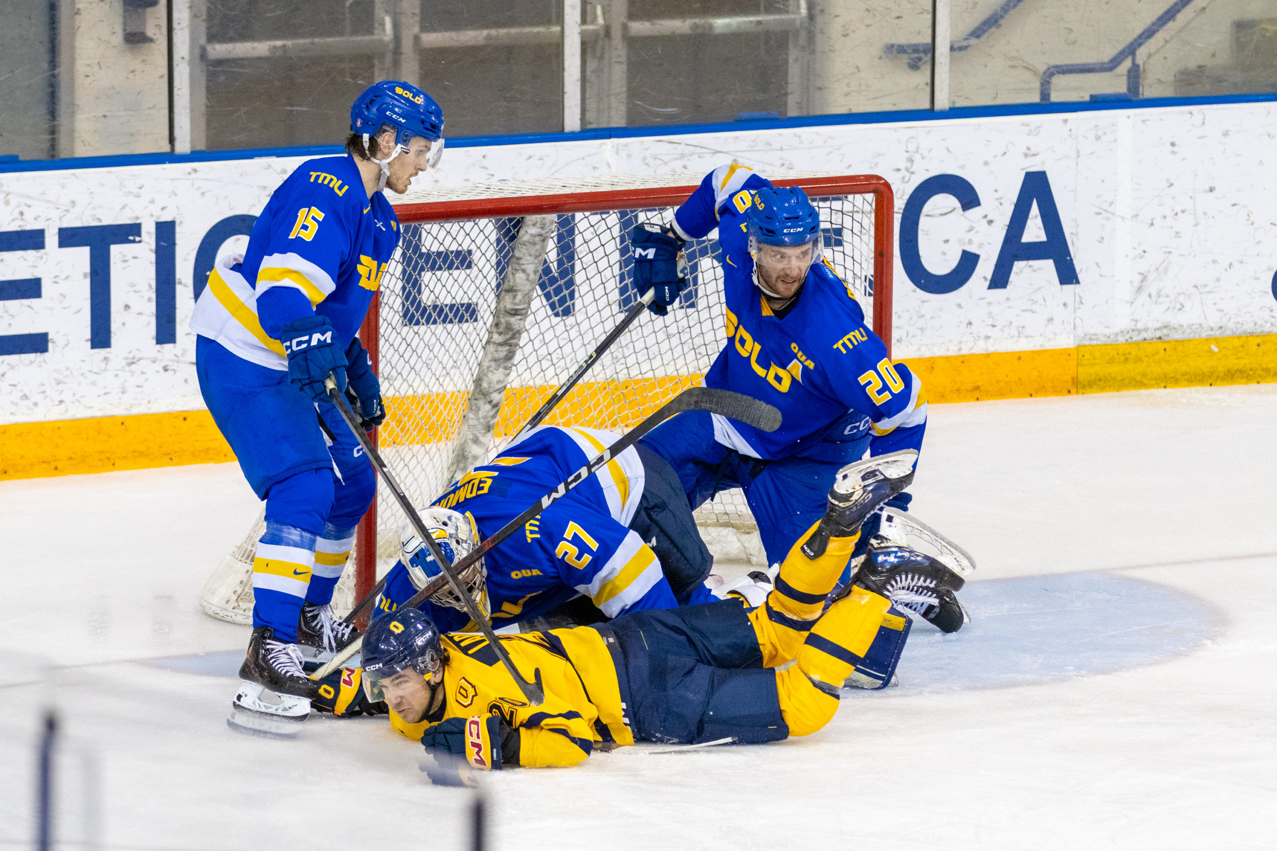 TMU's net gets scrappy, with Kai Edmonds and a Queen's player tangled together