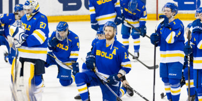 TMU, kneeling on the ice, accepts their bronze medal match defeat