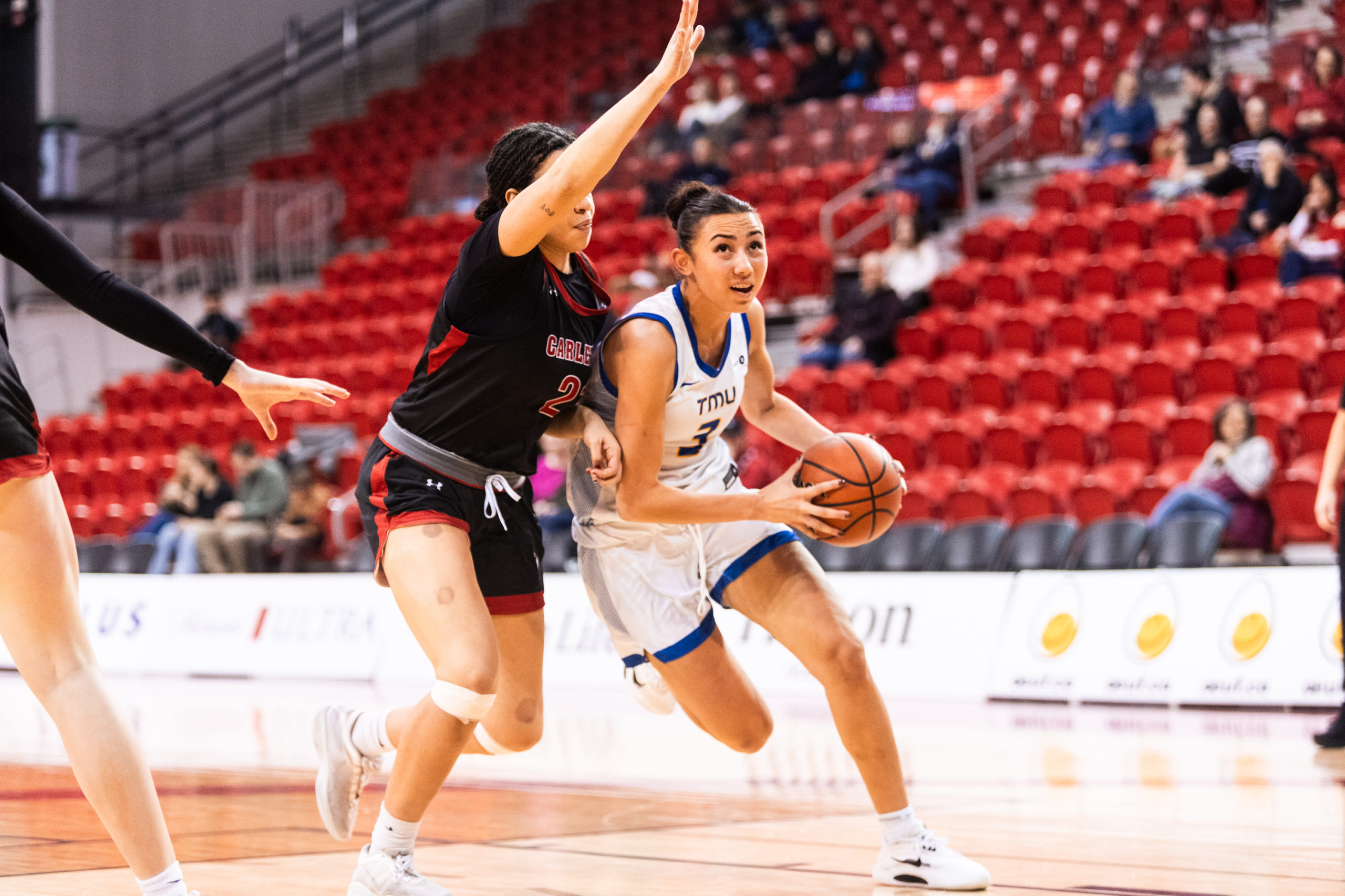 Hailey Franco DeRyck driving the ball against a Carleton defencer