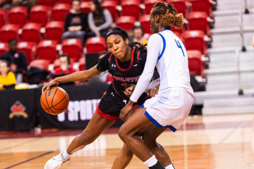 A Carleton player driving the ball against Myriam Kone
