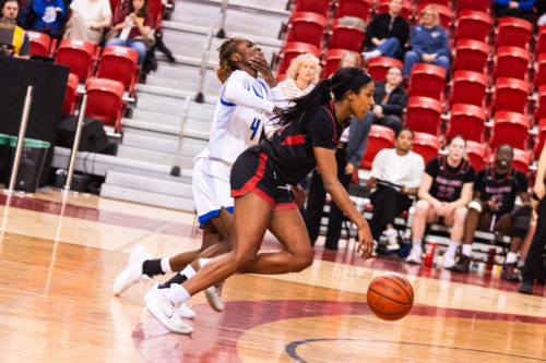 A Carleton player driving by Myriam Kone after inadvertently hitting her in the face