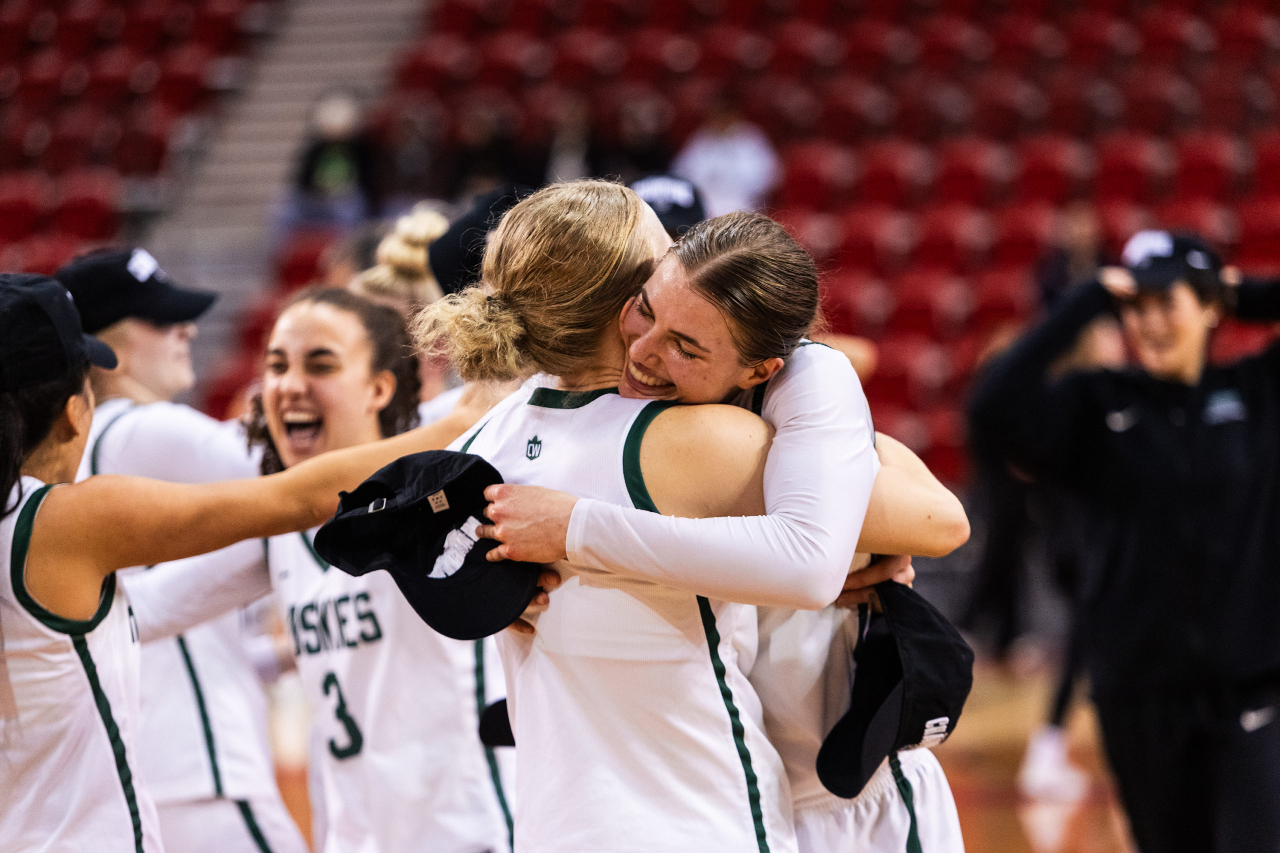 Two Huskies players embrace in a hug to celebrate their championship win
