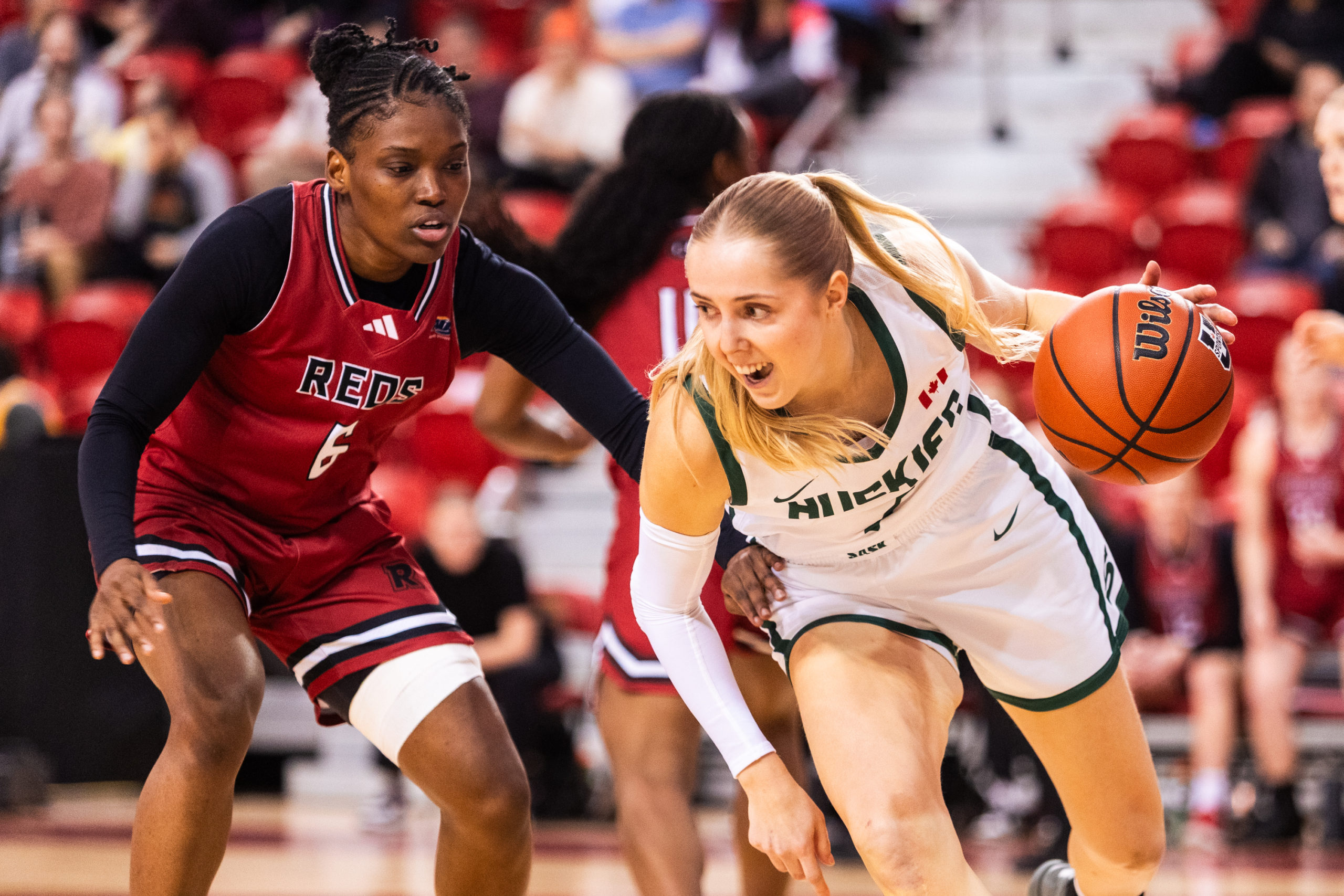A Huskies player maintains possession amidst a Reds opponent