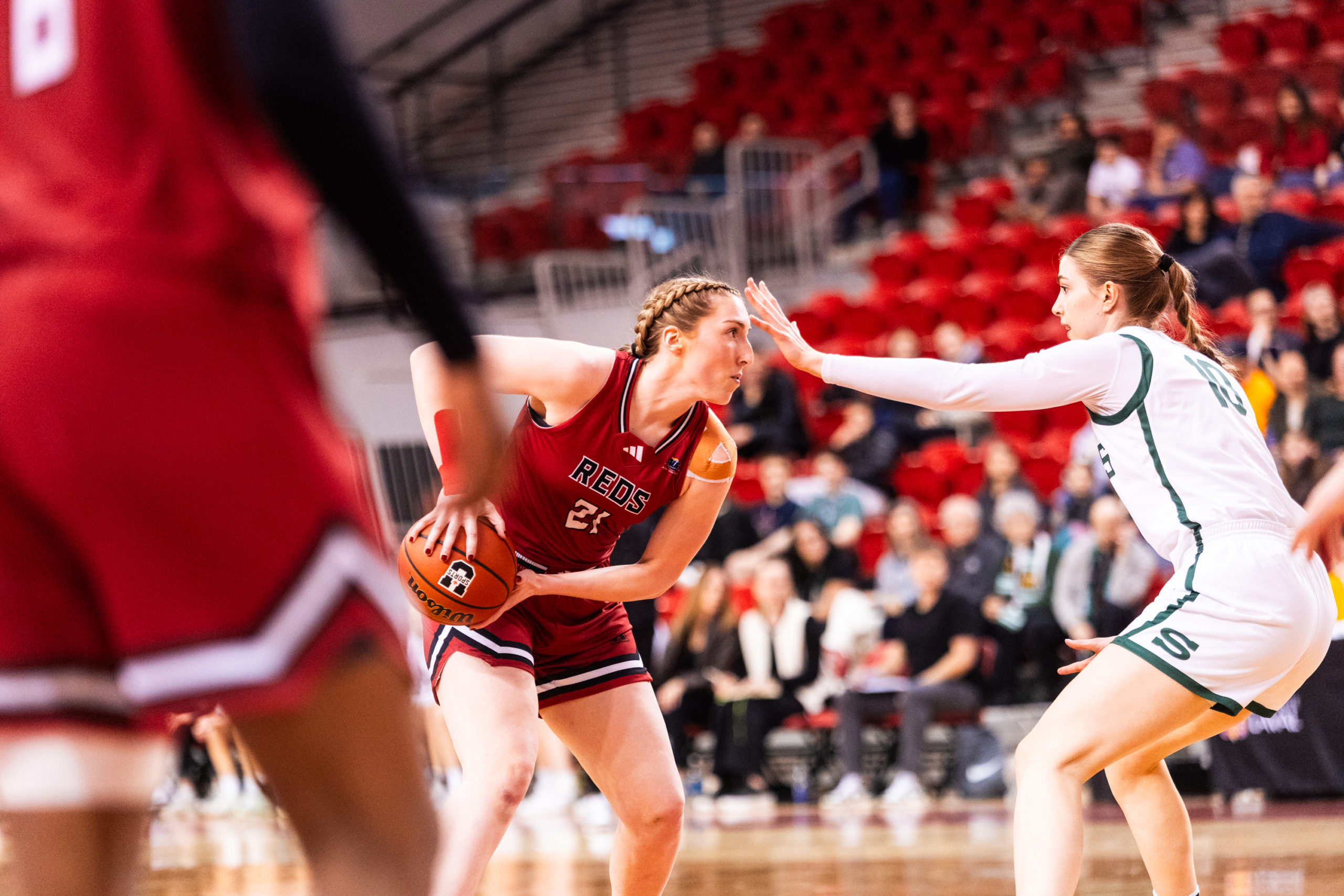 A Reds player scans where to pass as a Huskies player tries to block the ball