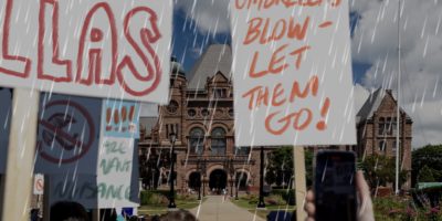 A photo illustration of a fake protest in the rain, protesting umbrellas