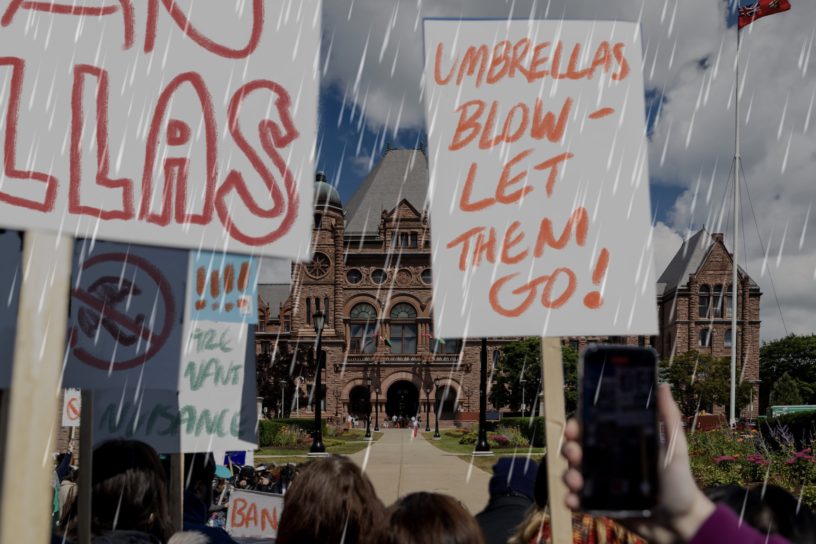 A photo illustration of a fake protest in the rain, protesting umbrellas