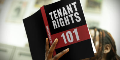 Photo of someone holding a book that reads "Tenant Rights 101".