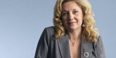 Dr. Roberta Iannacito-Provenzano wearing a grey blazer against a light blue background