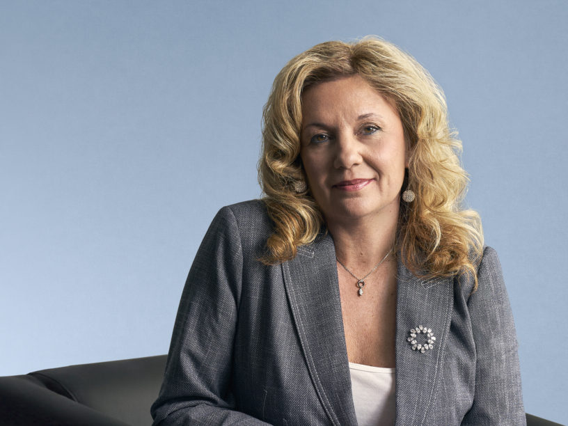 Dr. Roberta Iannacito-Provenzano wearing a grey blazer against a light blue background