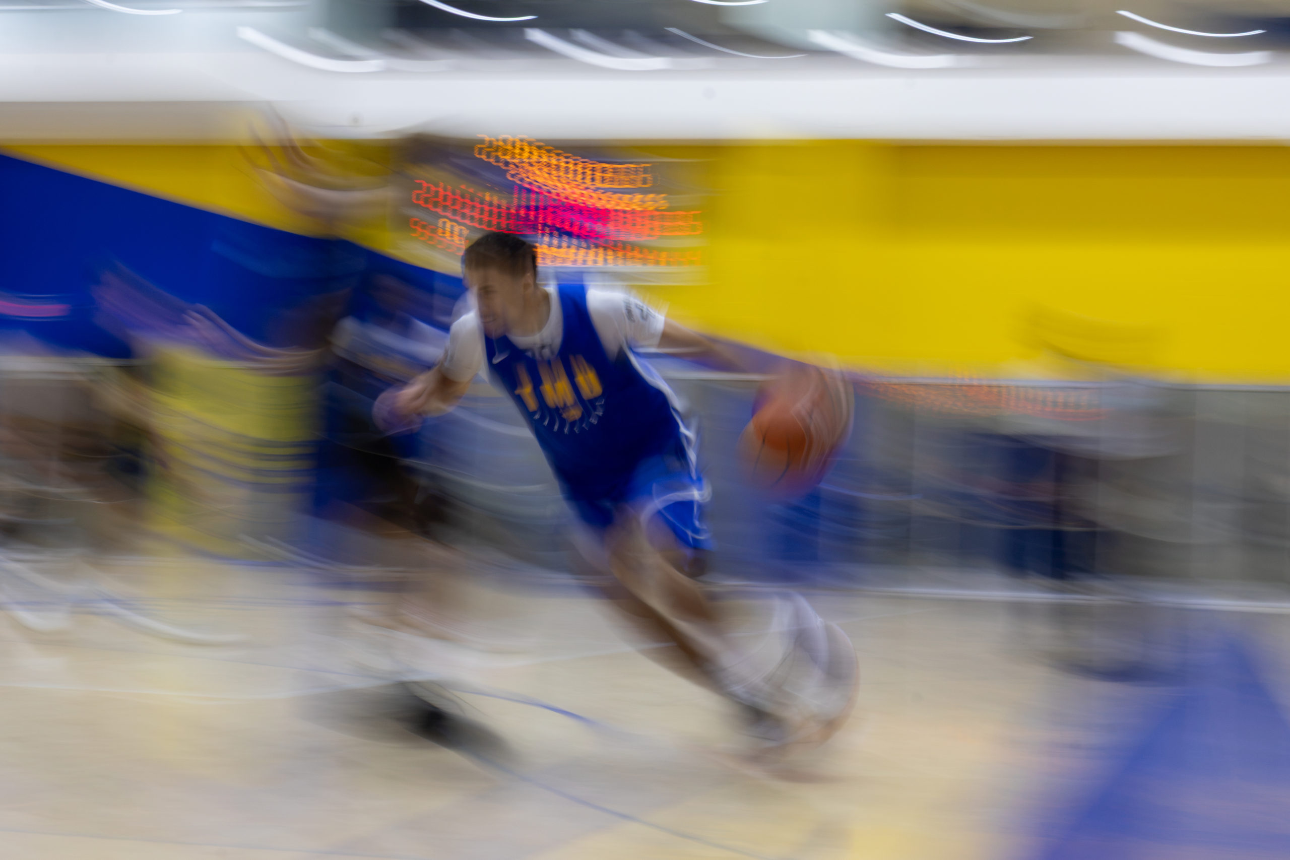 TMU guard Nathaniel Savage run with ball creating a blurry array