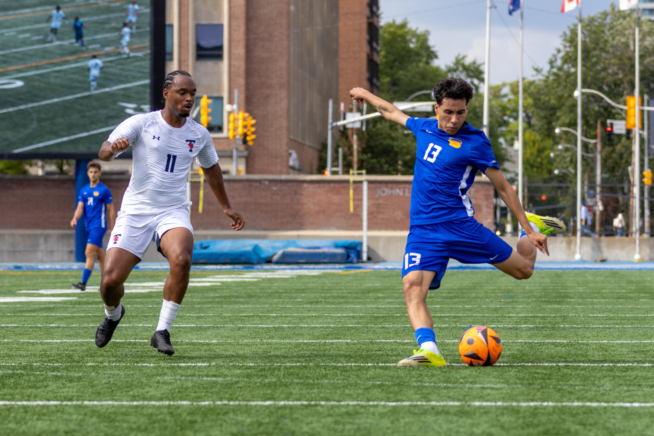 Opposing player watches as Bold player strikes the ball.