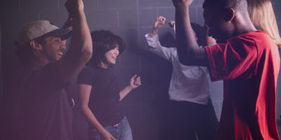 Students jump and dance on a night out.
