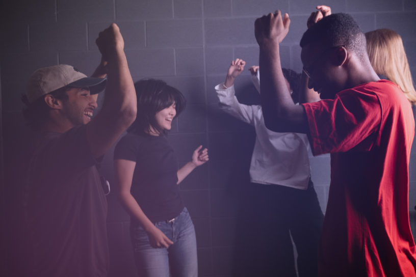 Students jump and dance on a night out.