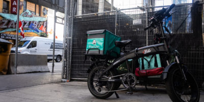 Photo of a E-bike parked alongside a gate.