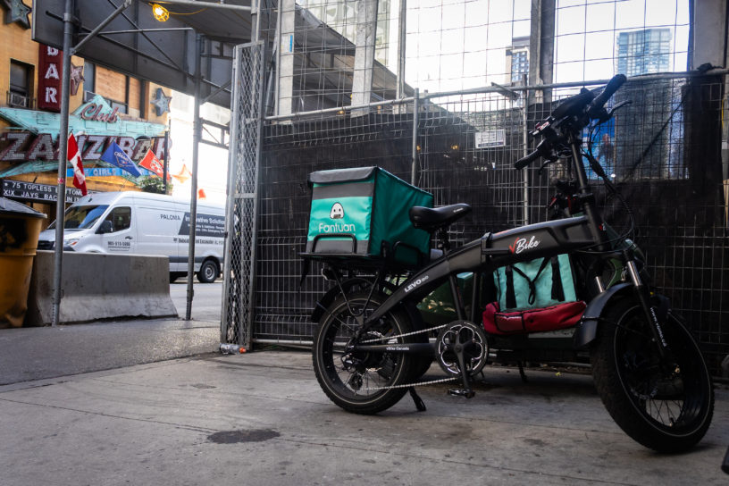 Photo of a E-bike parked alongside a gate.