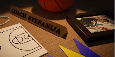 Desk featuring a basketball whiteboard, basketball, ribbons, and picture frame
