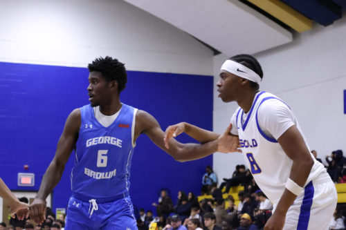 Two basketball players guard each other