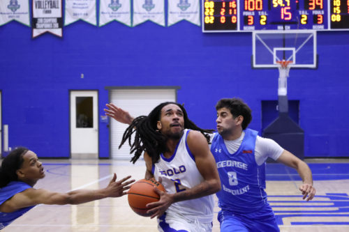 Two George Brown players reach for a TMU player holding the ball