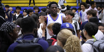 TMU men's basketball player high-fives fans