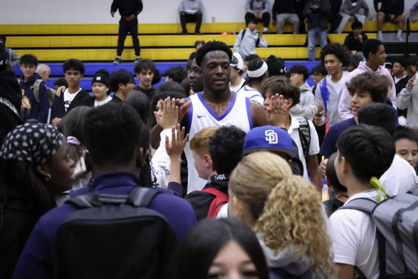 TMU men's basketball player high-fives fans
