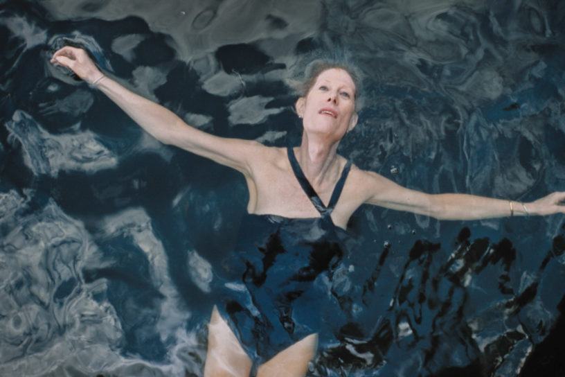 A still from the film Neverman. A women floats on her back in a body of water.
