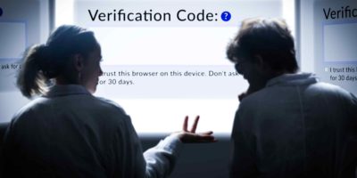 Image of two people looking a screen visibly confused, with the screen reading "Verification code:"