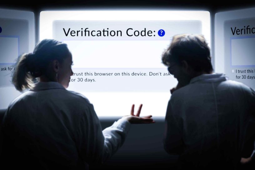 Image of two people looking a screen visibly confused, with the screen reading "Verification code:"