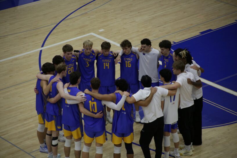 Bold volleyball athletes gather in team circle