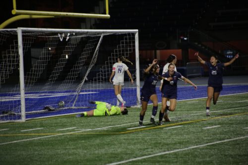 Three U of T soccer players celebrate a goal
