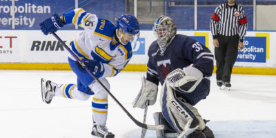 Bold men's hockey player, Carson Lloyd, tries to score a shootout winner against Blues goalie