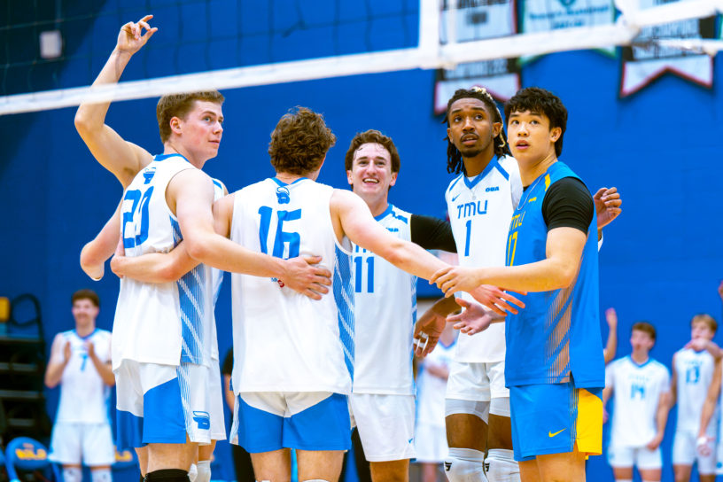 The Bold men's volleyball embrace at the net