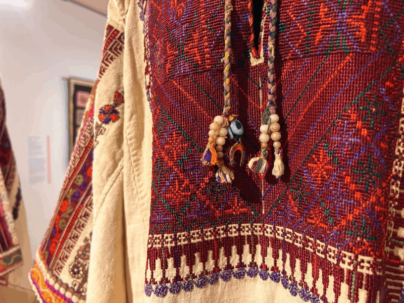 A photo from the Retracing Tatreez exhibit. It is a close-up detail shot of a garment.