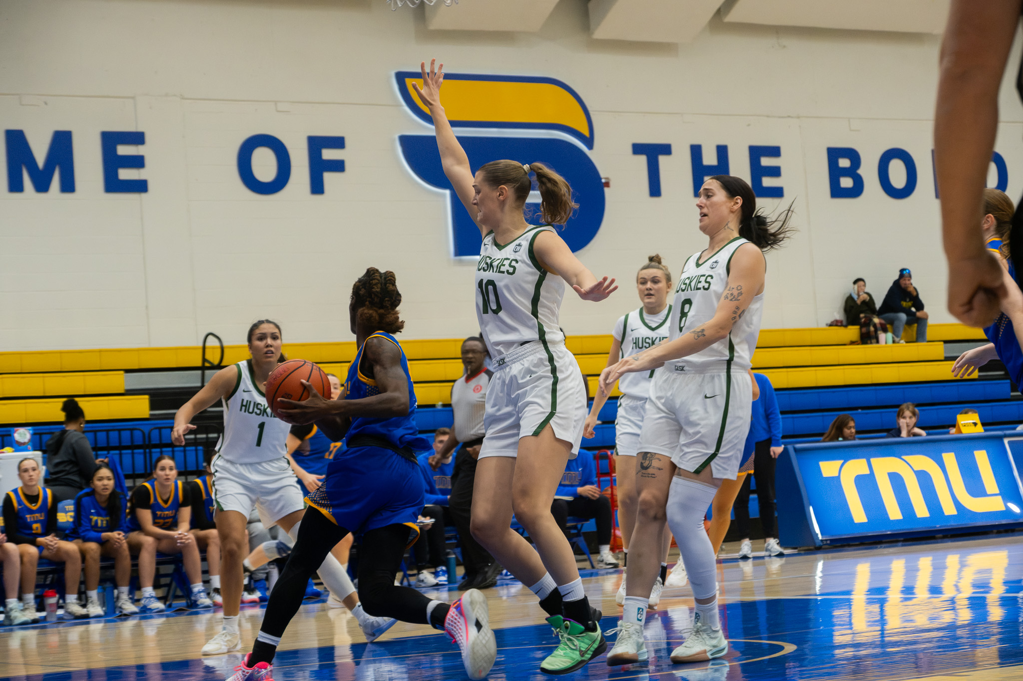 TMU basketball player guarded by three Saskatchewan players