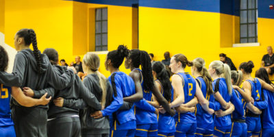 TMU Bold women's basketball team standing in a line for national anthem