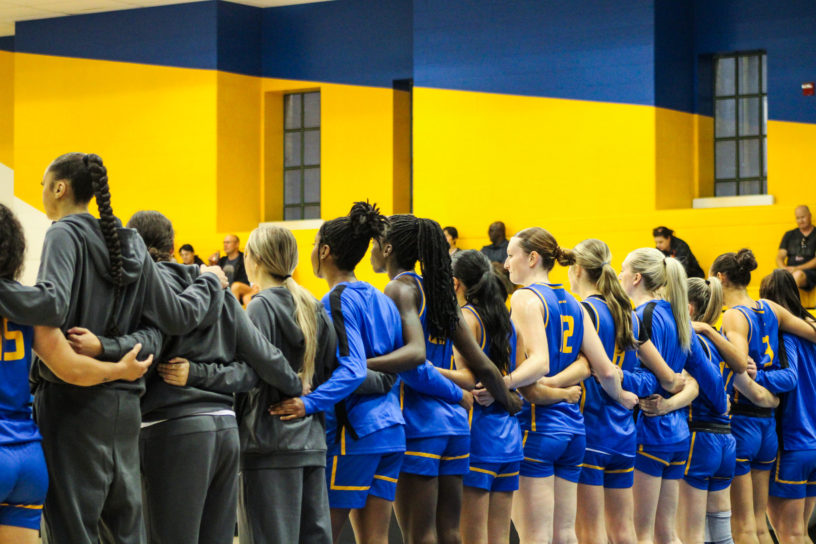 TMU Bold women's basketball team standing in a line for national anthem