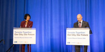 Olivia Chow and Brad Bradford stand behind podiums in the Student Learning Centre